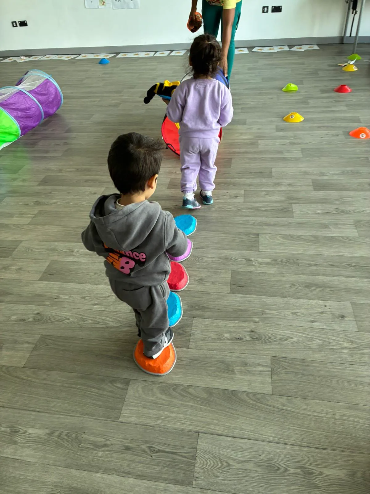 Two children taking turns on coloured stepping stones