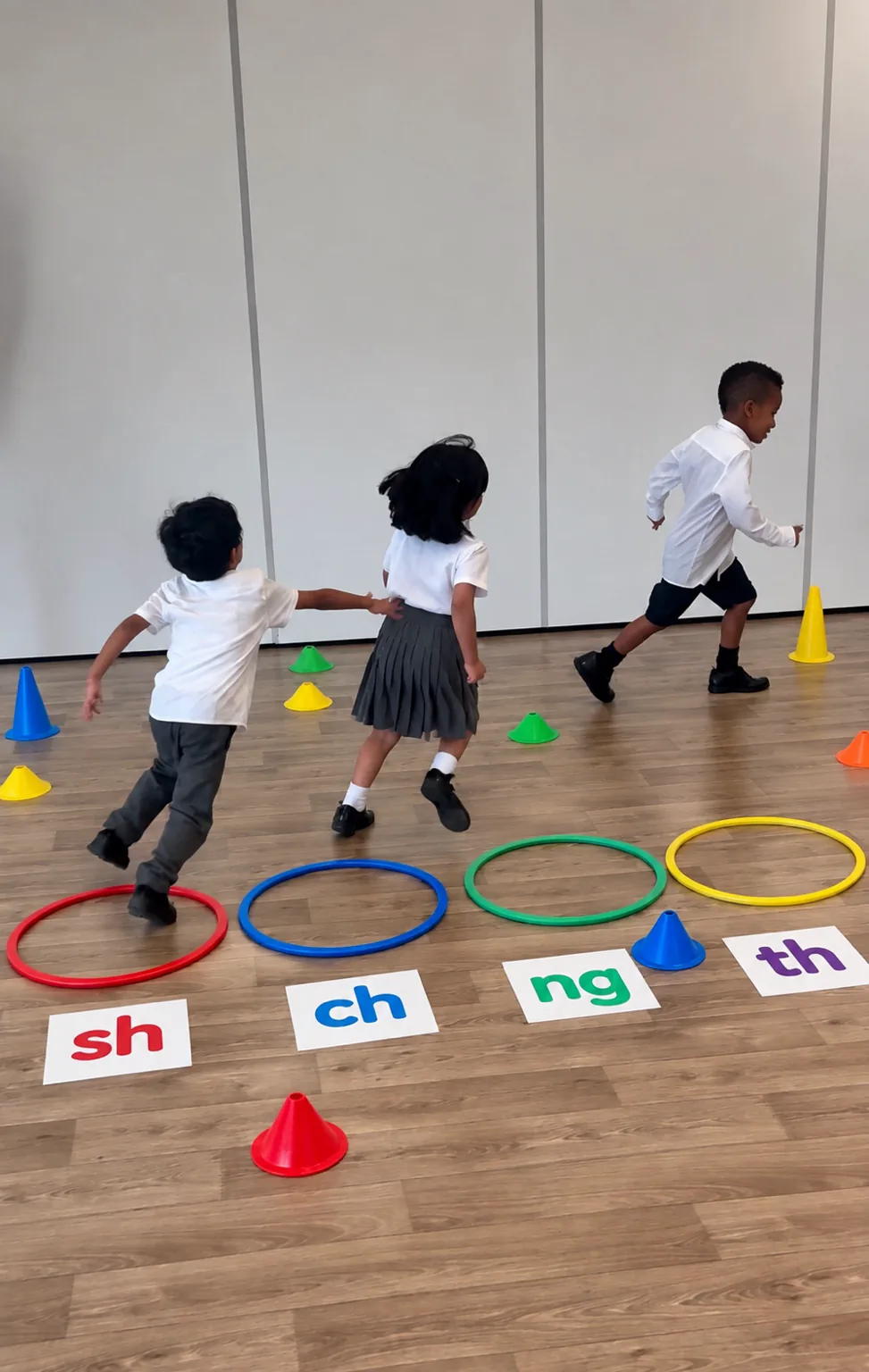 Reception and Year 1 children running to sh, ch, ng and th digraph cards