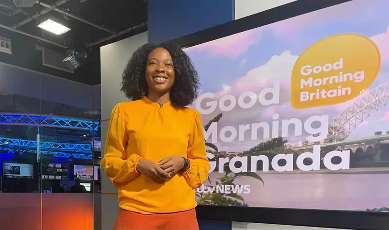 Natasha in front of a television studio screen